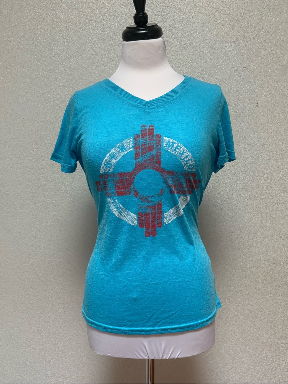New Mexico Zia symbol
Women’s Turquoise Graphic V-Neck Tee - Unbranded